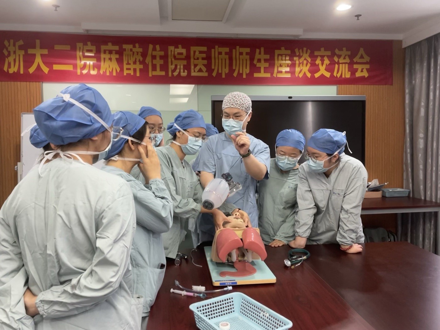 Dawei Sun demonstrating airway management using a training mannequin with students.